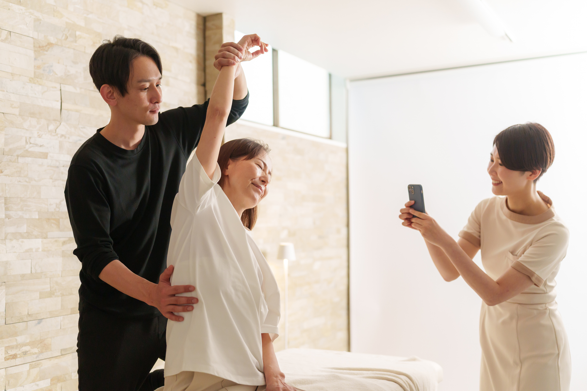 スマホでスタイル写真を撮影する美容師