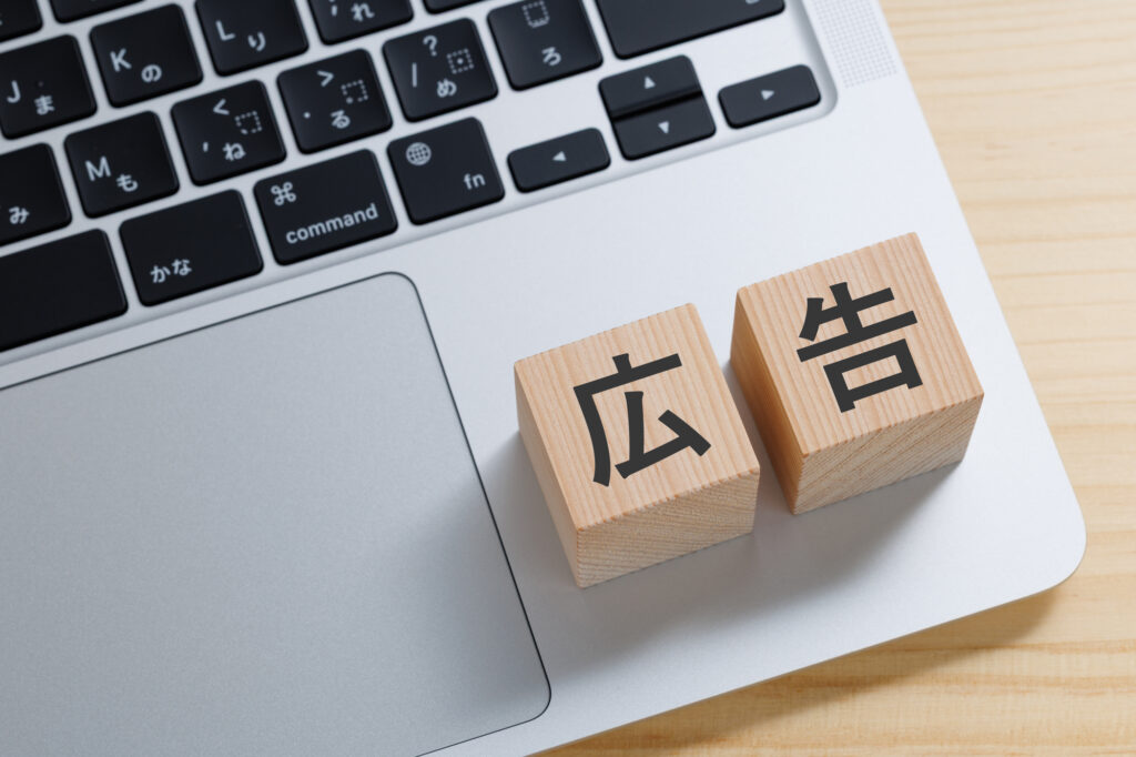 広告と書かれた積み木とノートパソコン